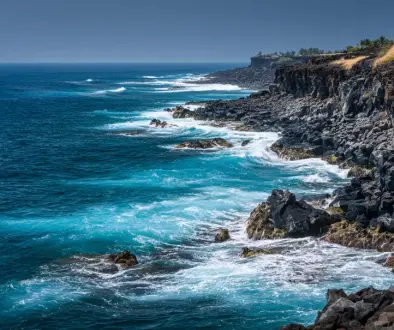 黒い溶岩と青い海が広がるハワイ島の力強い海岸風景
